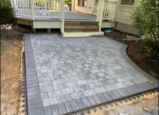 New gray paver patio under a white deck