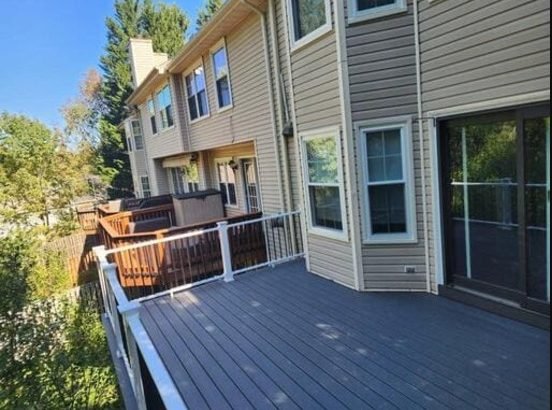 Deck with white and black railing on a two-story townhouse