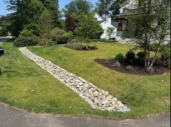River rock drainage with a freshly installed lawn
