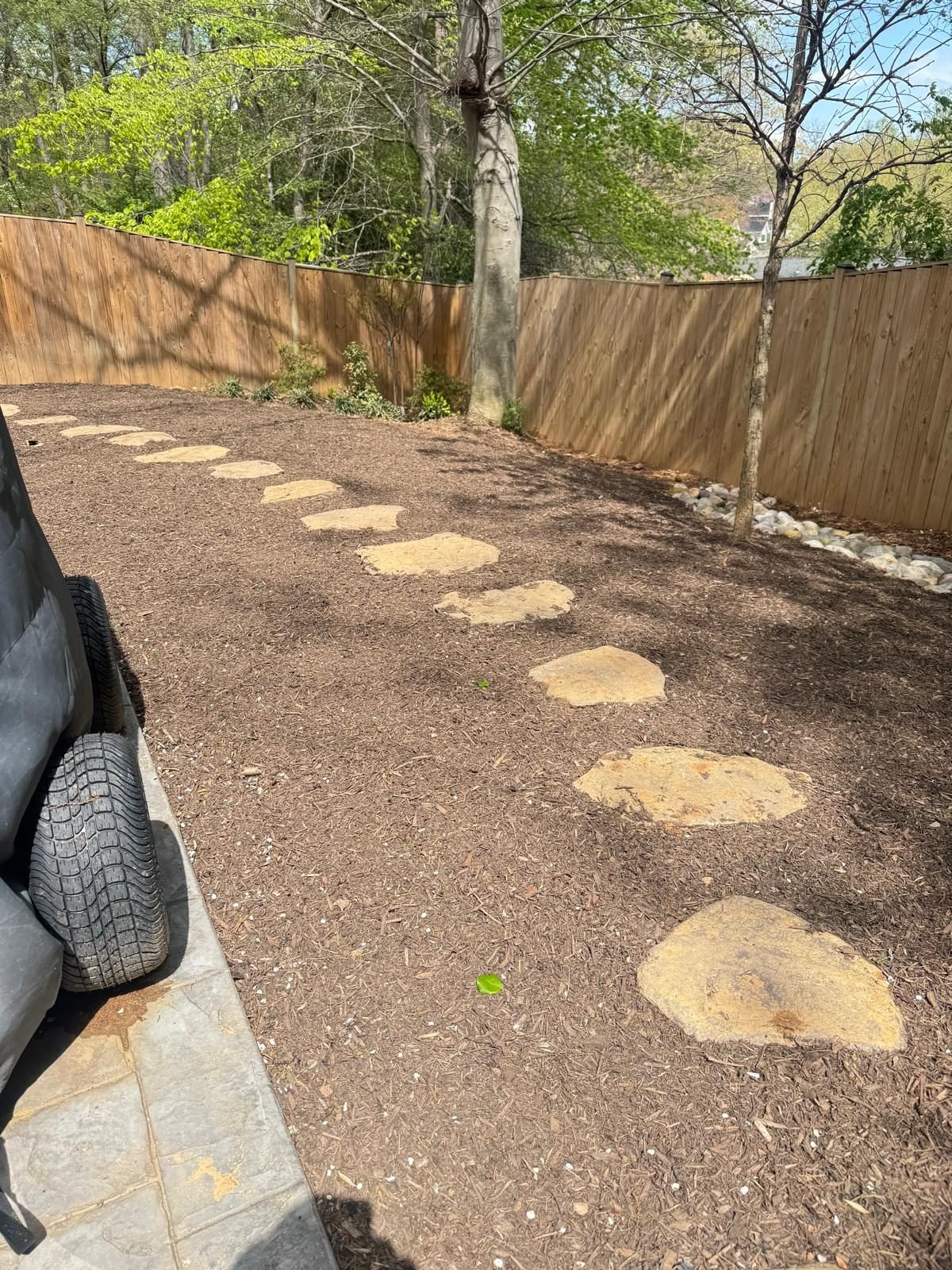 Flagstone stepping path along a wood fence