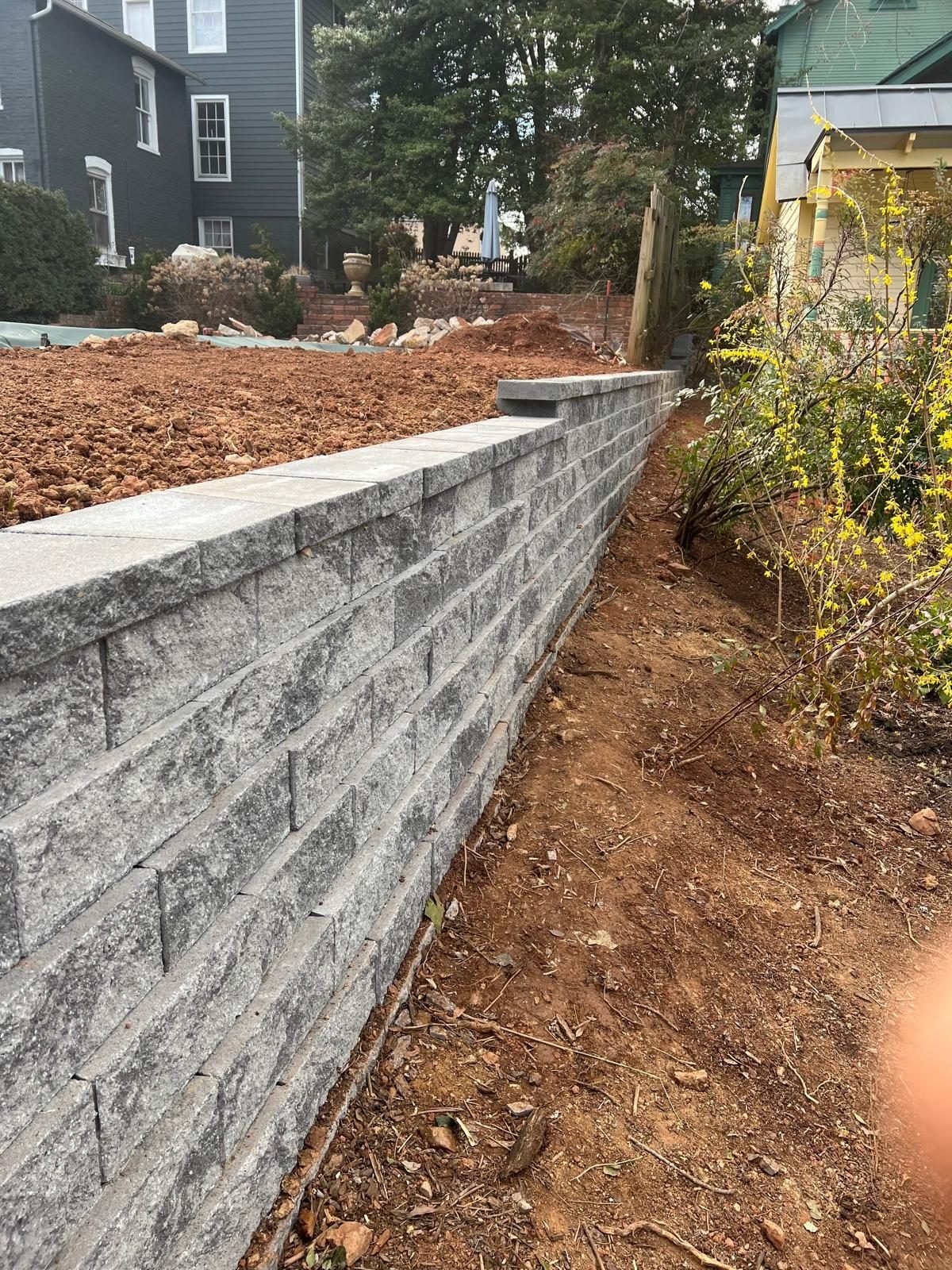 Finished gray block retaining wall on a sloped lot