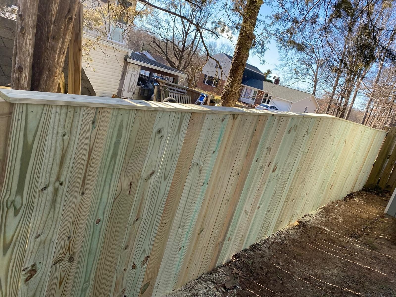 New wood privacy fence on a sloped backyard