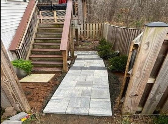 Paver walkway leading to wooden deck stairs