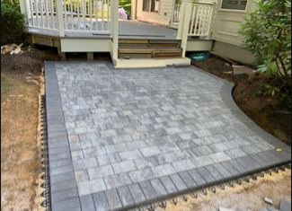 New gray paver patio under a white deck