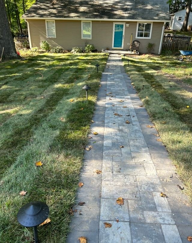 Paver walkway to the front door with garden lights